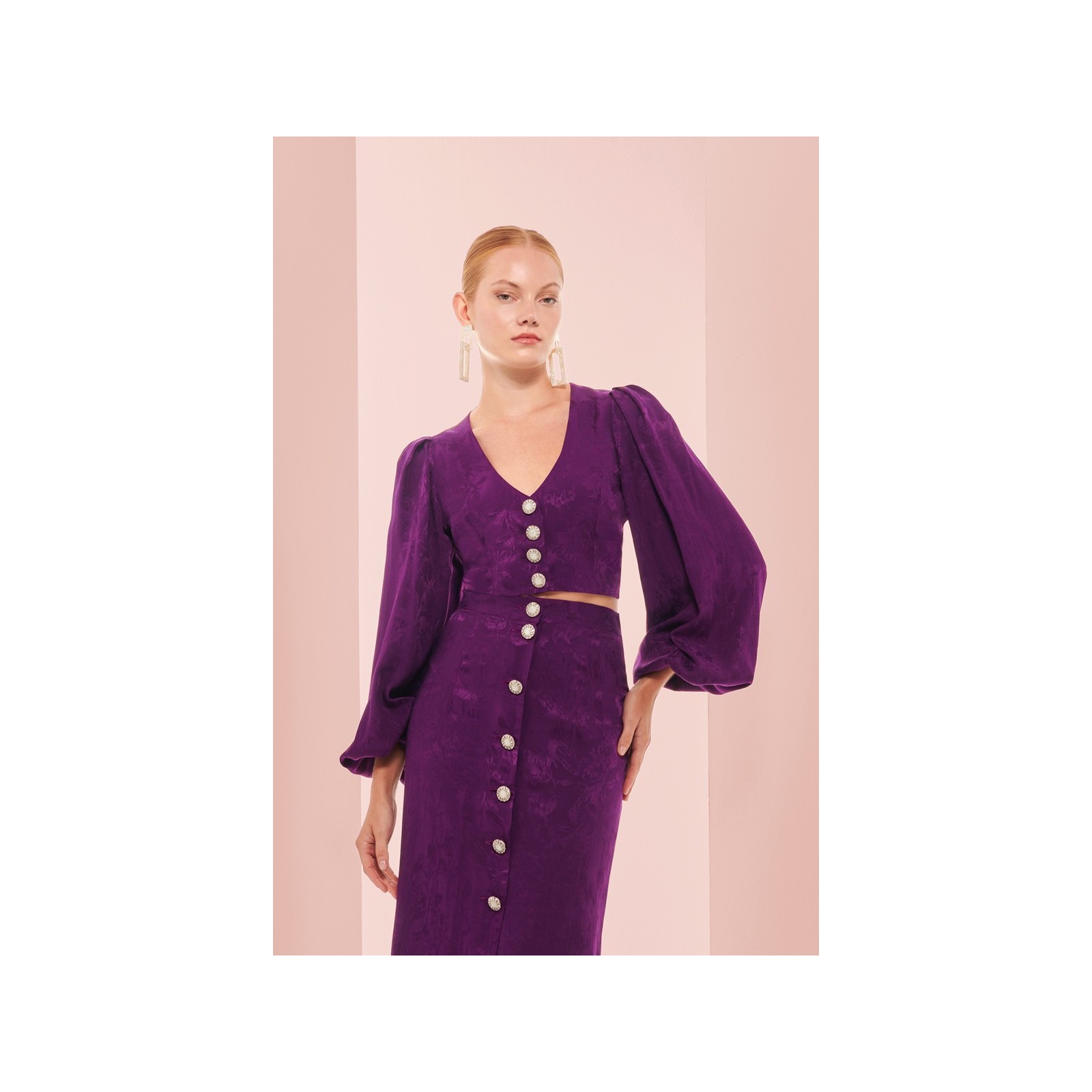 top morado con escote en pico boton joya y manga ablusonada
