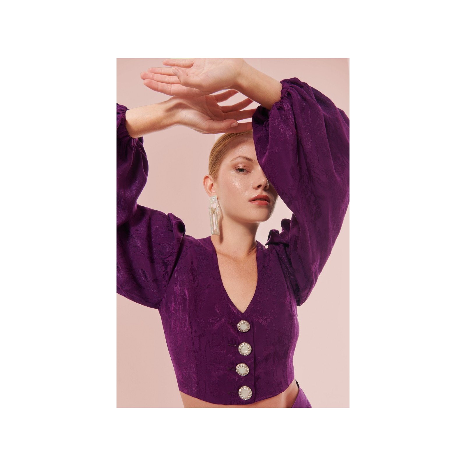 top morado con escote en pico boton joya y manga ablusonada