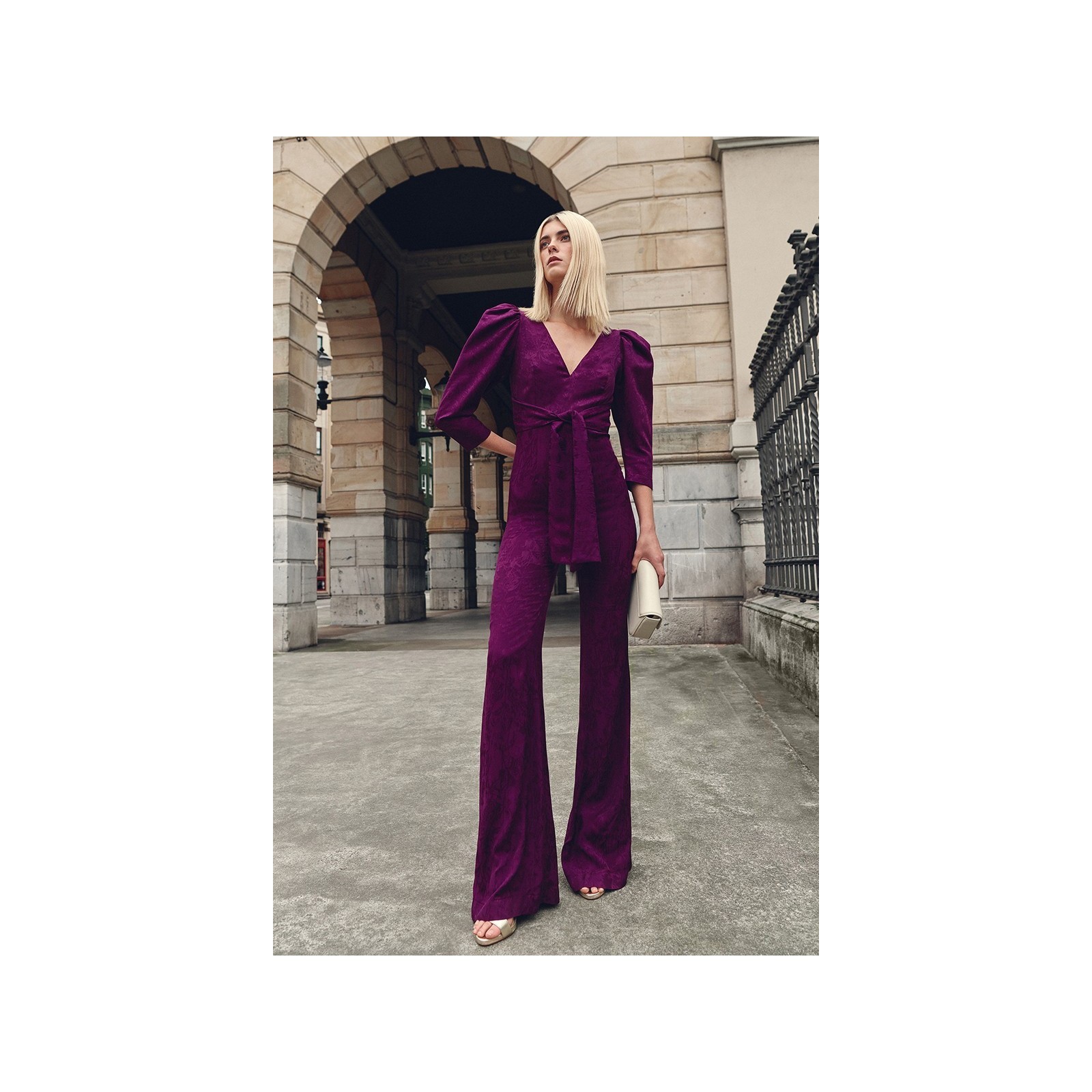 Mono de fiesta morado con manga abullonada y lazada para invitadas