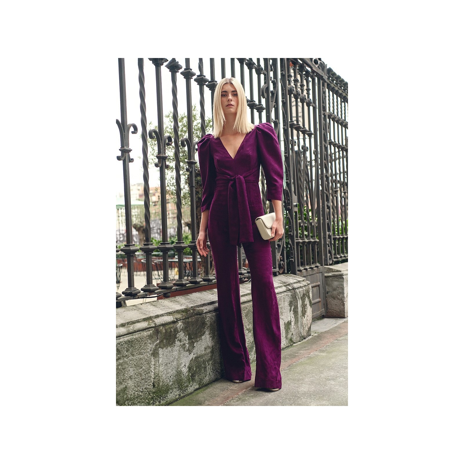 Mono de fiesta morado con manga abullonada y lazada para invitadas