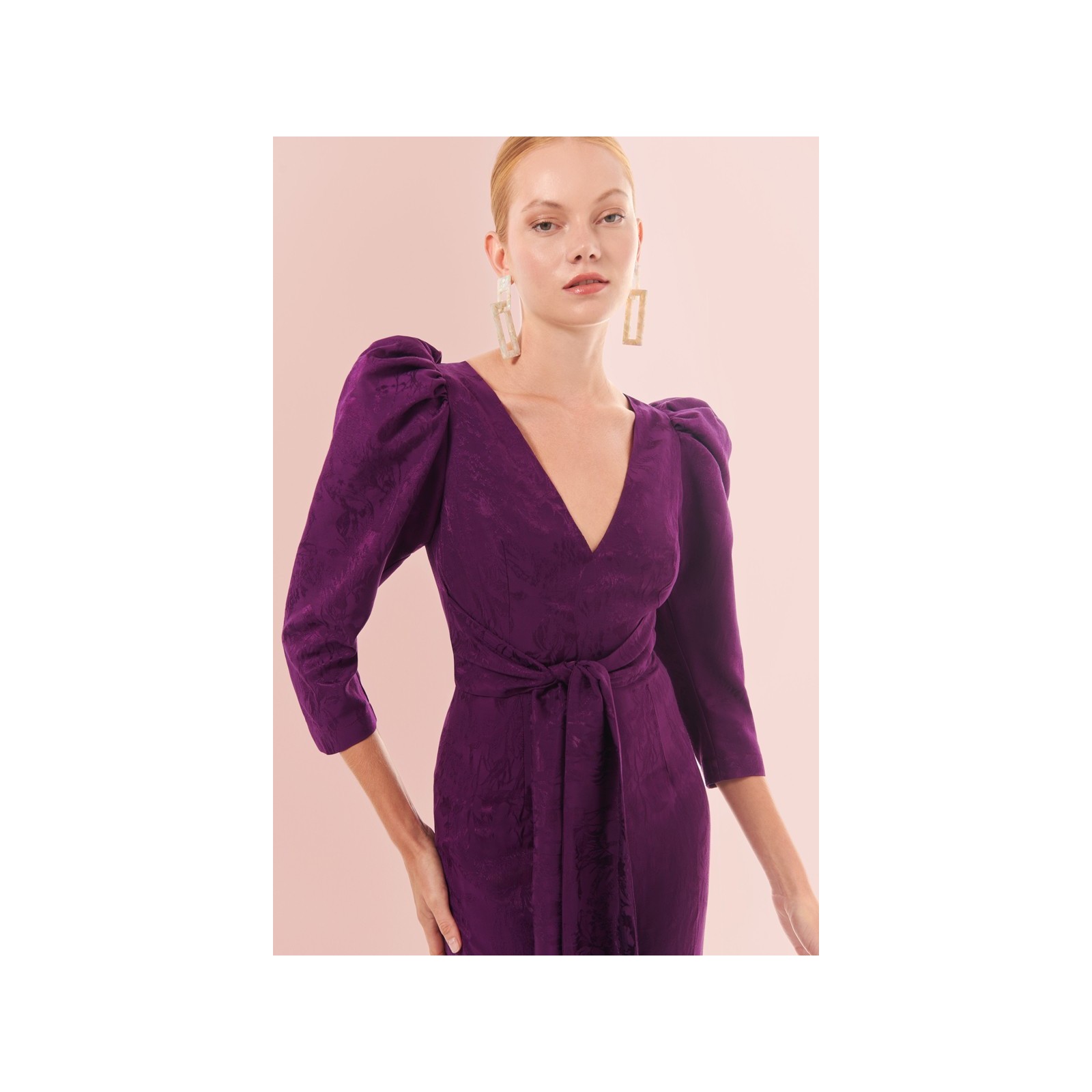 Mono de fiesta morado con manga abullonada y lazada para invitadas