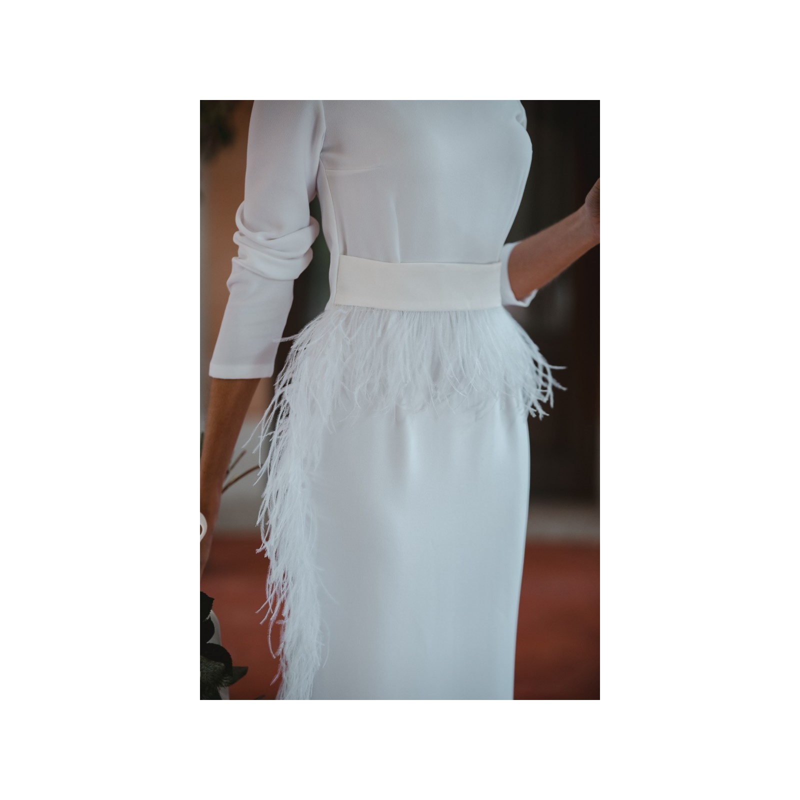 Vestido midi blanco con manga larga y pluma en cintura y falda