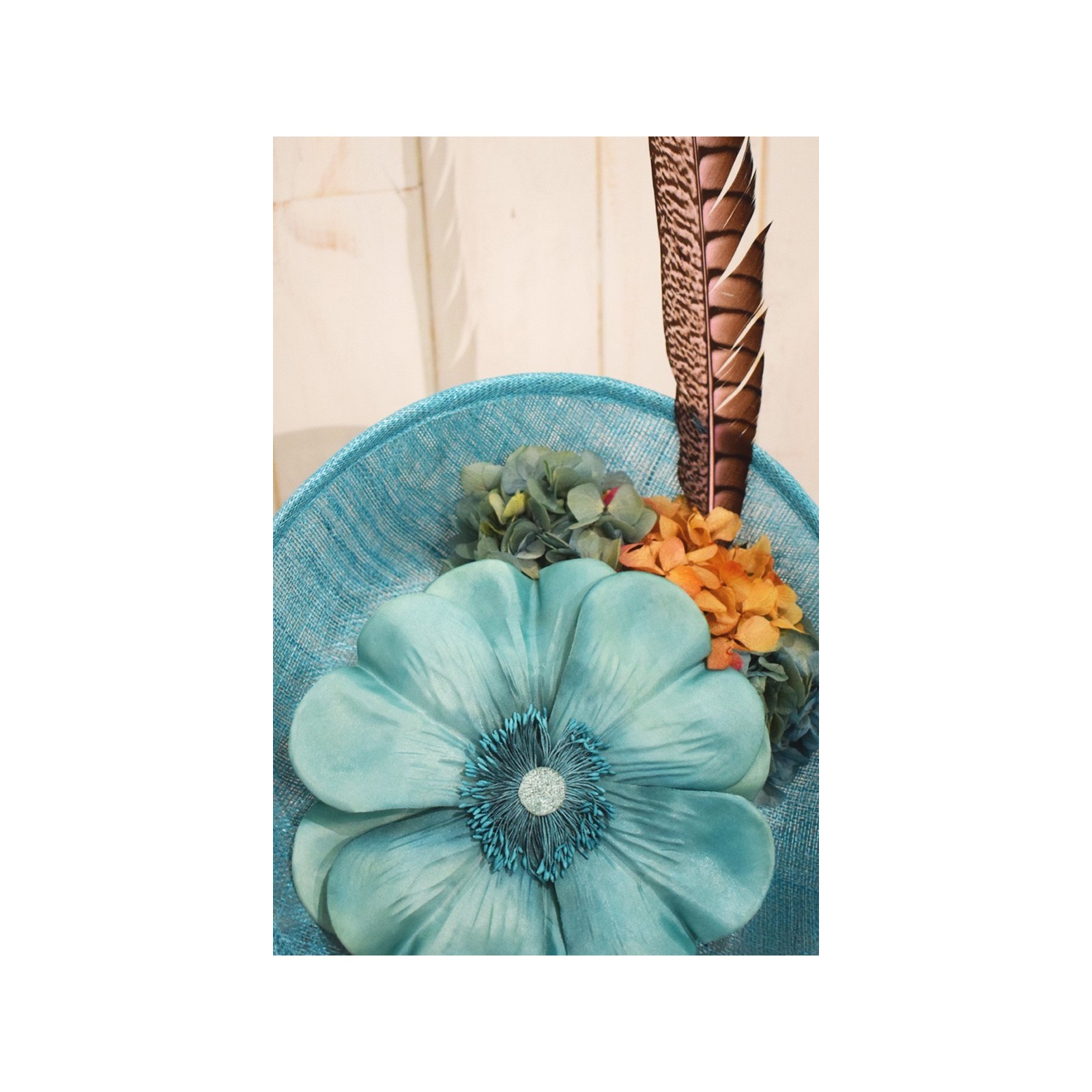 tocado azul claro con flor grande y pluma faisan