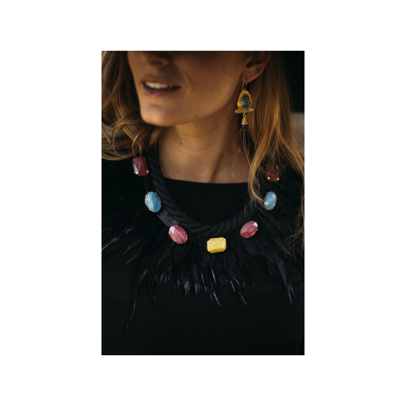 Complemento de collar negro con plumas negras y predería de colores